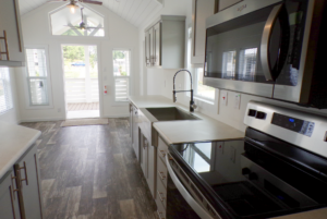 Red Maple tiny home kitchen with stainless steel appliances.
