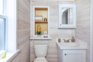 Grande tiny home bathroom with built-in storage shelves and medicine cabinet.
