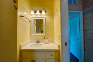 Vanity sink in tiny home with yellow walls.