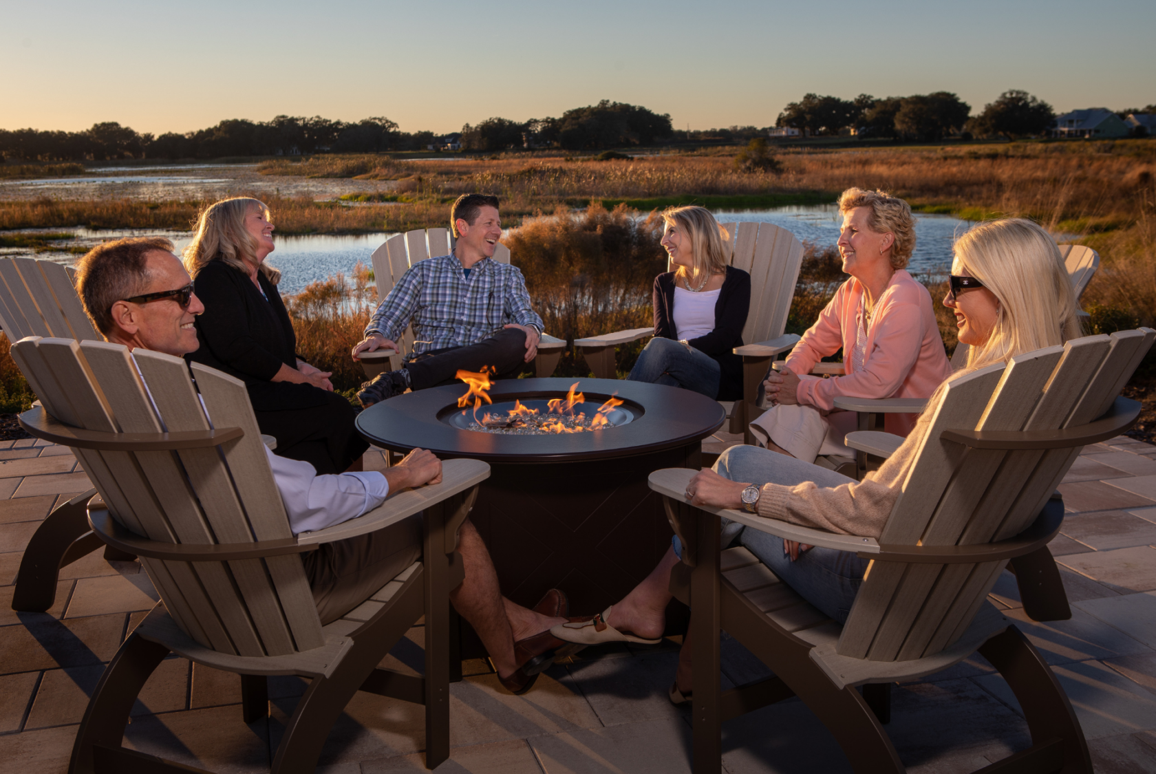 Residents gathered around the firepit in front of Lake Andrew at sunset.