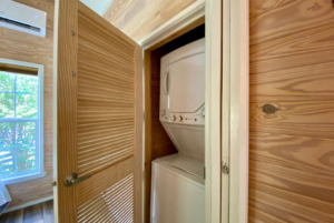 Laundry space in tiny home with stackable washer and dryer.