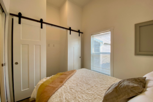 This bedroom is located at the rear of the home and is filling with natural light from the large window.