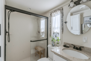 Sedona tiny home bathroom with round mirror and walk in shower.