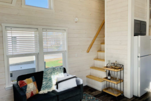 Horseshoe tiny home living room and loft staircase.