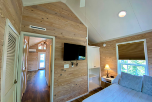 Tiny House bedroom with wallmount tv and built-in storage.