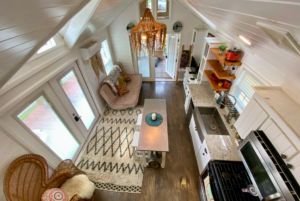View of living space and open concept tiny house from the loft space.