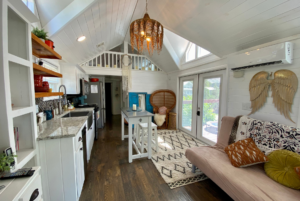 Open concept tiny home with kitchen and living room.
