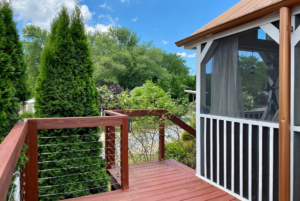 Deck entrance with large bush and view of trees.