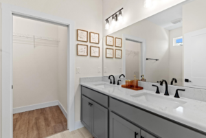 Double sink vanity and walk in closet in cottage home for sale by Simple Life at Lakeshore.
