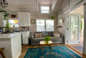 Living room in 400 sqft tiny home with multiple windows, large french doors and rustic flair.