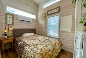 bedroom with multiple windows in small home.