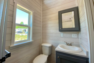 Bathroom in tiny house with pharmacy cabinet and window