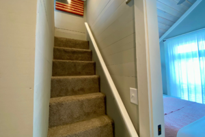 Carpeted stairs leading to the loft of this tiny house.