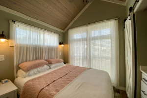 Tiny home bedroom with multiple windows and plenty of natural light