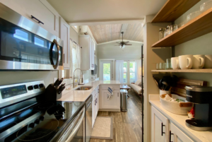 Kitchen space in tin home with mocrowave, oven and ample storage.