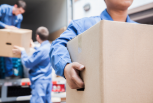 Group of people moving someone's belonging from one home to another.