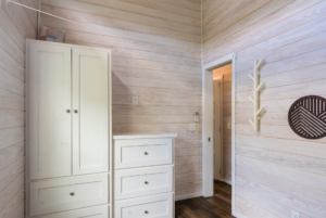 Tiny home bedroom with built-in furniture providing ample storage.