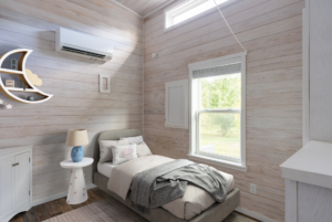 Staged bedroom in tiny home with high ceilling.