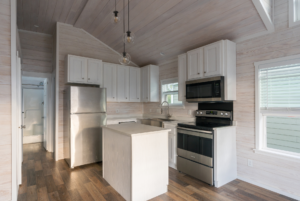 Kitchen in tiny home with ample storage andd modern design.