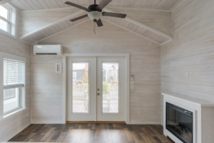 Tiny house living space with high ceillings, ceilling fan and large window.