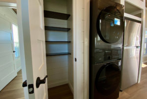 pantry space next to laundry appliances in tiny house