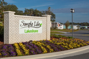 Lakeshore entrance sign with view of manufactured homes in the background.