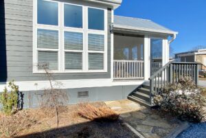 Side of the home with view of walking path and stairs leading to porch