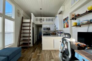 View of tiny home kitchen with view of loft above the kitchen