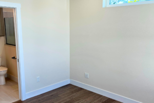 Bedroom in cottage home with large baseboards and bathroom