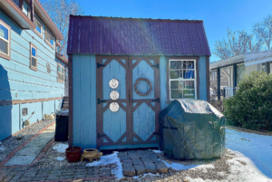 light blue shed next to tiny home