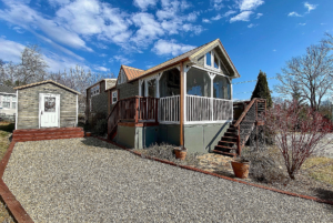 view of tiny home lot with driveway and shed