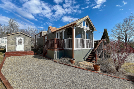 view of tiny home lot with driveway and shed