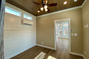 View of bedroom with high ceilling, ceilling fan and wall AC