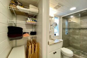 Wire shelves and stacked chairs beside a bath with shower at 40 Drifting Brook Lane real estate.