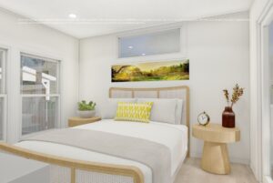 Bright bedroom with large windows, a cozy bed with white and yellow pillows, and wooden furniture.