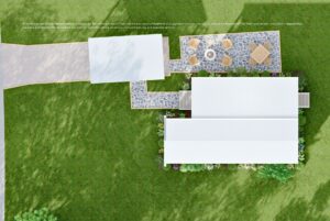 Aerial view of a house with a stone patio, outdoor tables, walkway, driveway, and green lawn.
