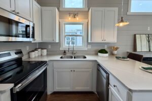 Modern kitchen at 124 Misty Knoll Way with white cabinets, stainless steel appliances, and a window above the sink.