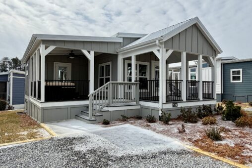 Small, modern gray cottage at 124 Misty Knoll Way with two covered porches, steps, and minimal landscaping.