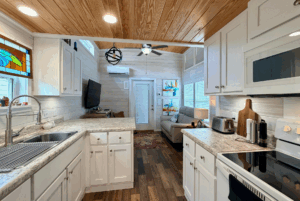 Compact, modern kitchen at 44 Skipping Stone Lane opens to a cozy living area with wood accents and bright decor.