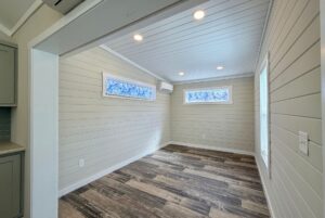 Bright empty room with white shiplap walls, wood-style flooring, and a peaceful Strolling Easy Lane vibe.