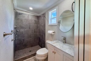 Modern bathroom with a walk-in shower, gray tiles, and white vanity—perfect for strolling Easy Lane in style.