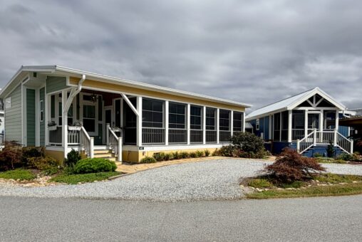 Two small houses with screened porches line Strolling Easy Lane, nestled under a cloudy sky.