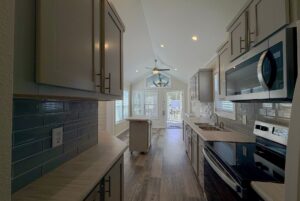 Modern galley kitchen with gray cabinets, stainless appliances, and patio views for strolling Easy Lane living.