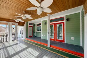 Bright sunroom with wood ceiling and green walls, perfect for Strolling Easy Lane and enjoying red-trimmed doors and big windows.