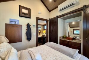 Cozy bedroom with patterned bedding, wall art, and a view into office and bath at 54 Highland Hollow.