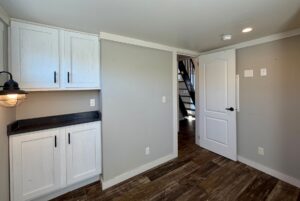 Small room with white cabinets, wood floors, and staircase—charming real estate at 139 Drifting Brook Lane.