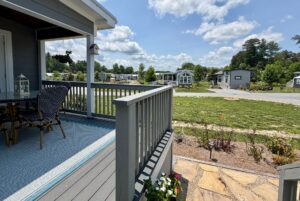 A small porch with chairs on Mount Meadow Lane overlooks a landscaped yard and several tiny houses on a sunny day.
