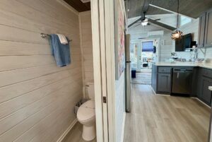 Modern bathroom with a towel, beside the kitchen and living area in a Mount Meadow Lane tiny house.