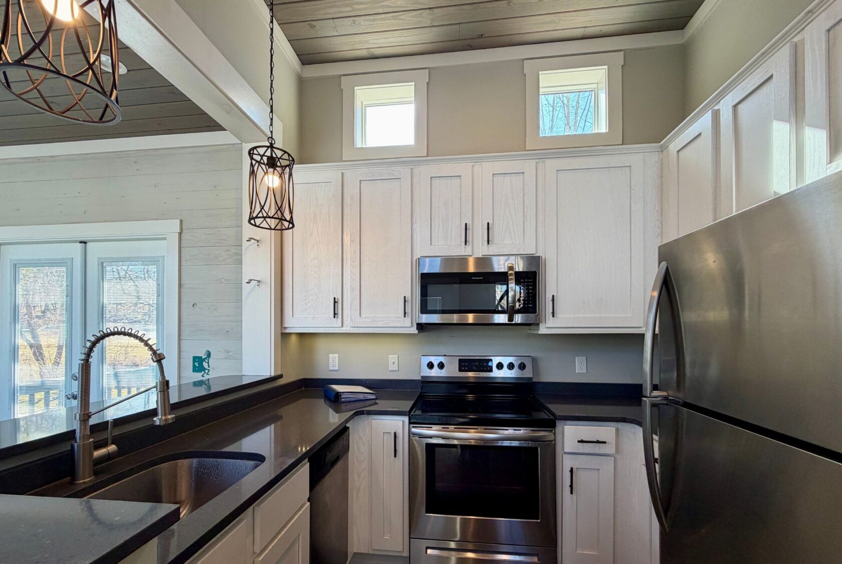 Modern kitchen at 139 Drifting Brook Lane with white cabinets, stainless steel appliances, and pendant lights.