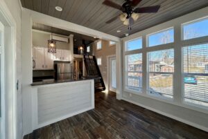 Modern kitchen and living area at 139 Drifting Brook Lane with wooden floors, large windows, and a loft staircase.